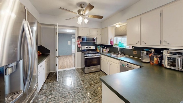 kitchen featuring ceiling fan, sink, stainless steel appliances, and white cabinets