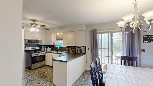 kitchen with white cabinetry, kitchen peninsula, hanging light fixtures, sink, and appliances with stainless steel finishes