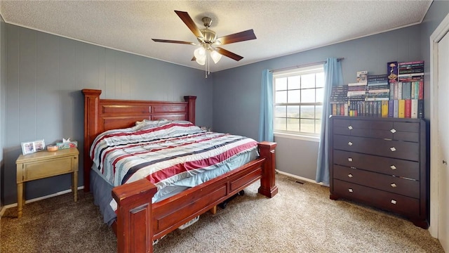 bedroom with ceiling fan, carpet floors, and a textured ceiling