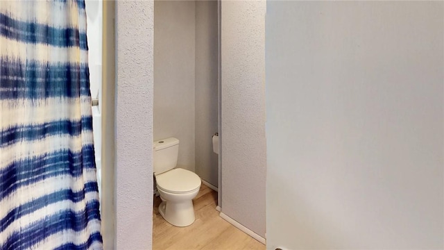 bathroom with toilet and wood-type flooring