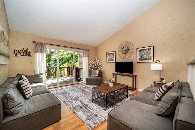 living room featuring light hardwood / wood-style floors and vaulted ceiling