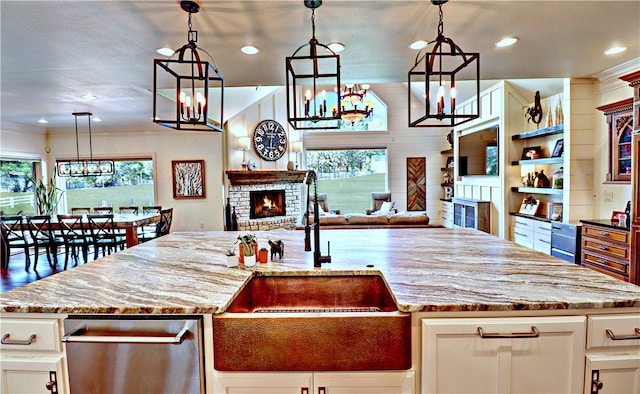 kitchen with decorative light fixtures, a fireplace, and plenty of natural light