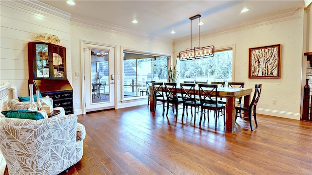 dining space featuring ornamental molding, an inviting chandelier, and dark hardwood / wood-style flooring