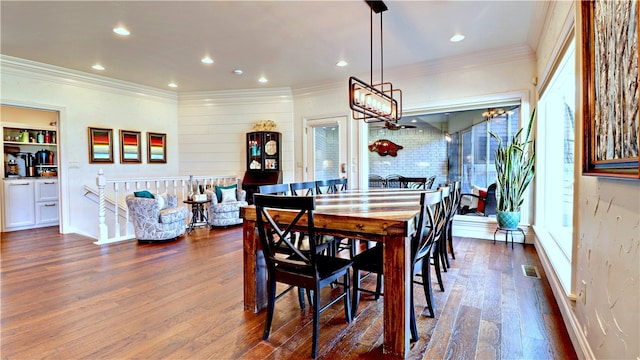 dining space with ornamental molding and dark hardwood / wood-style floors