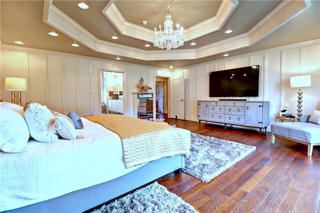 bedroom with a notable chandelier, a tray ceiling, crown molding, and dark hardwood / wood-style flooring