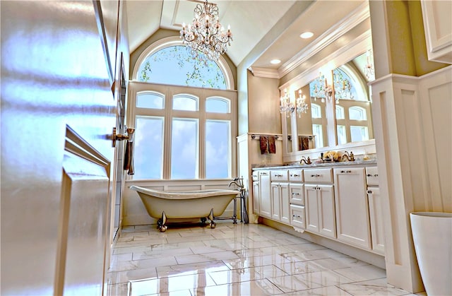 bathroom with vanity, ornamental molding, a chandelier, a tub to relax in, and vaulted ceiling