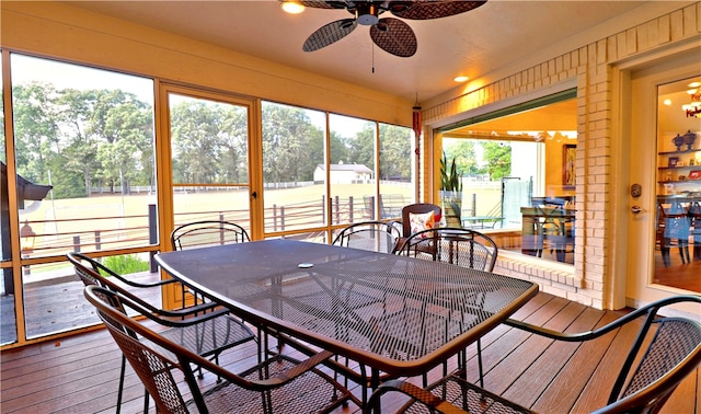 sunroom / solarium featuring ceiling fan, plenty of natural light, and a water view