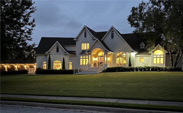 french provincial home with a front yard and a porch