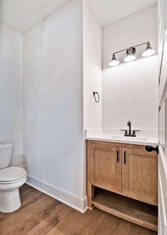 bathroom with vanity, wood-type flooring, and toilet