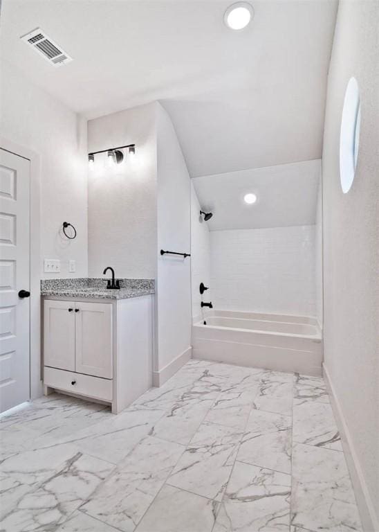 bathroom featuring tiled shower / bath and vanity