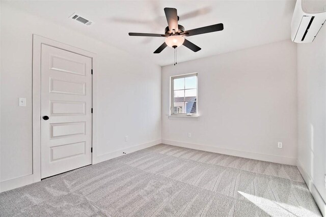 carpeted empty room featuring ceiling fan and a wall mounted air conditioner