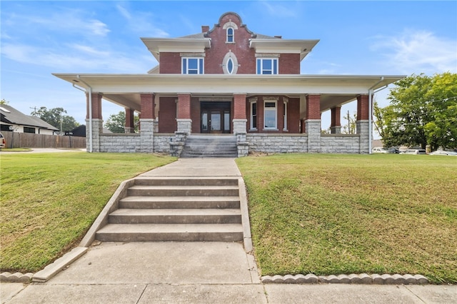 view of front facade with a front yard and covered porch