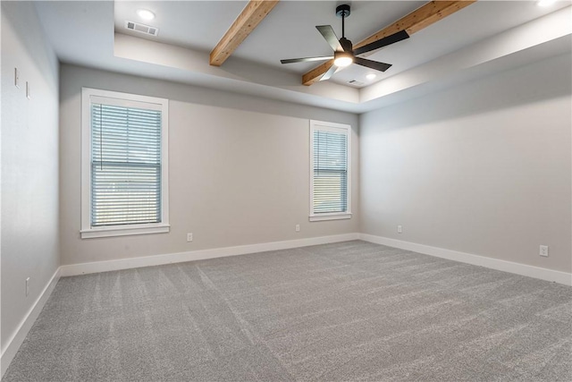 carpeted empty room featuring beamed ceiling, a raised ceiling, and ceiling fan