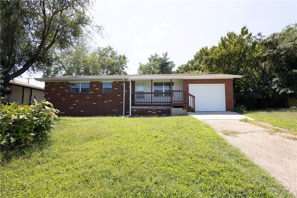 single story home featuring a front yard, a garage, and covered porch