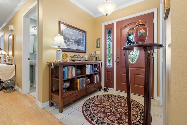 entryway with light wood-type flooring and crown molding