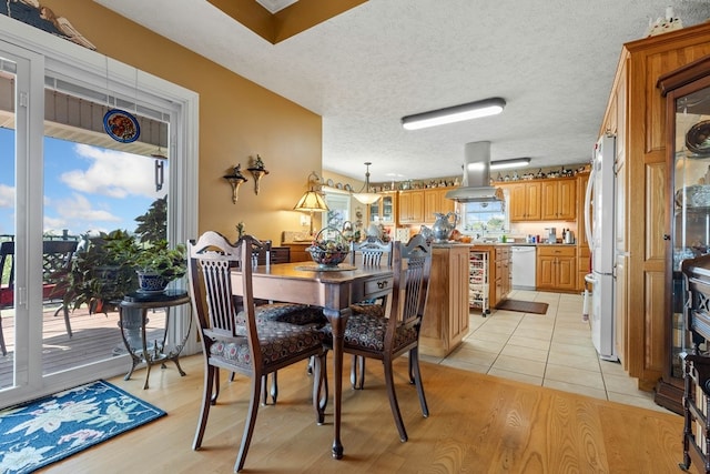 dining space featuring light hardwood / wood-style flooring and a textured ceiling