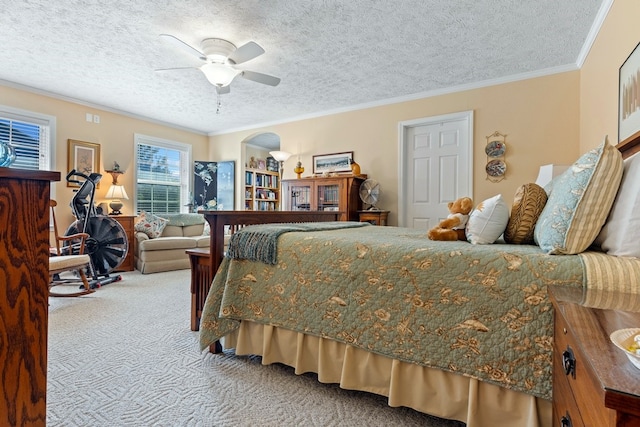 carpeted bedroom featuring a textured ceiling, ornamental molding, and ceiling fan