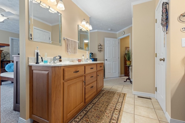 bathroom with a textured ceiling, tile patterned floors, crown molding, ceiling fan, and vanity