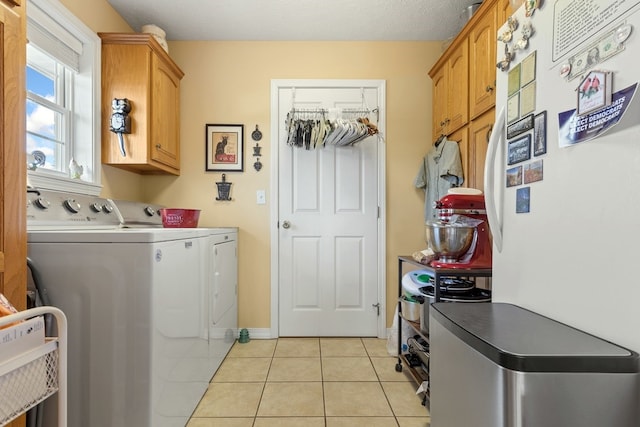 laundry room featuring cabinets, light tile patterned floors, separate washer and dryer, and a textured ceiling