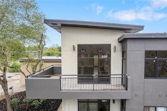 exterior space featuring a balcony and stucco siding