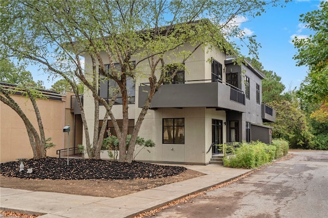 contemporary house featuring a balcony and stucco siding