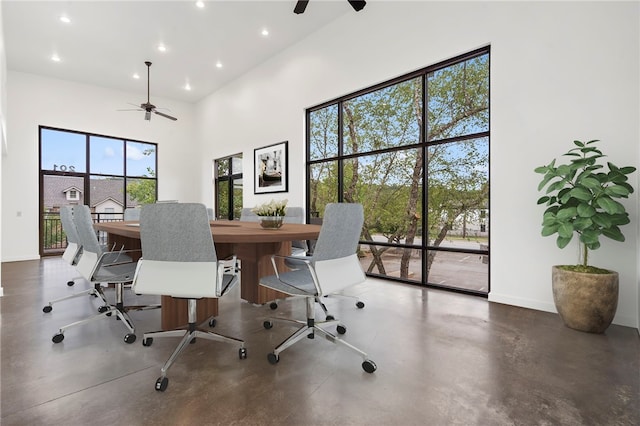 home office with a high ceiling, ceiling fan, and plenty of natural light