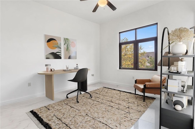 home office with marble finish floor, ceiling fan, and baseboards