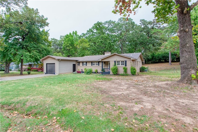 ranch-style home featuring covered porch, a front yard, and a garage