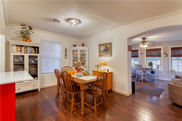 dining area with ceiling fan, a textured ceiling, crown molding, and dark wood-type flooring