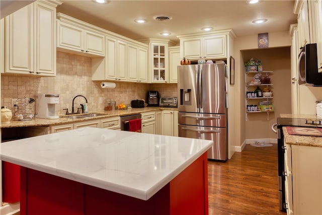 kitchen with tasteful backsplash, stainless steel appliances, a center island, dark hardwood / wood-style floors, and sink