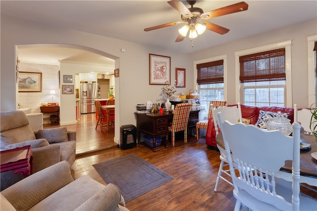 living room featuring ceiling fan, ornamental molding, and dark wood-type flooring