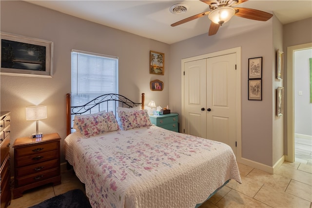 bedroom with a closet, light tile patterned flooring, and ceiling fan