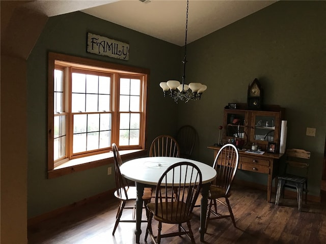 dining room featuring an inviting chandelier, vaulted ceiling, and dark hardwood / wood-style flooring