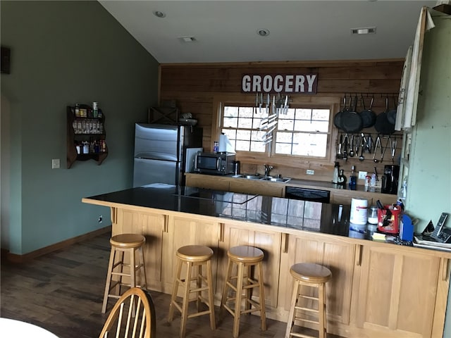 kitchen featuring dark hardwood / wood-style floors, sink, kitchen peninsula, a kitchen breakfast bar, and black appliances