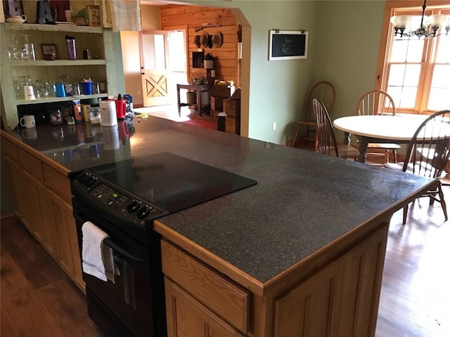 kitchen featuring a notable chandelier, dark wood-type flooring, and black electric range