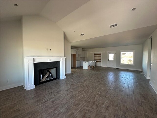 unfurnished living room with dark hardwood / wood-style flooring and lofted ceiling