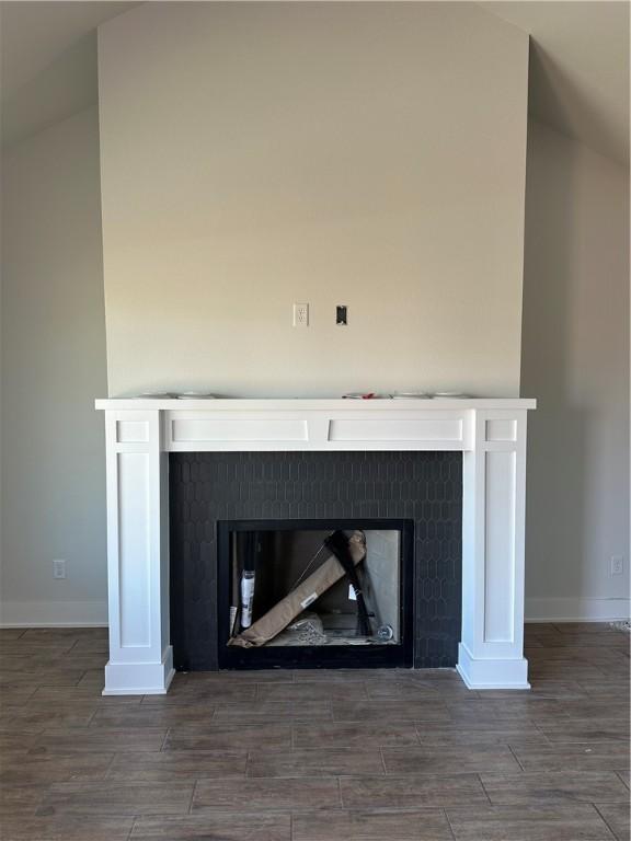 room details featuring a tile fireplace and wood-type flooring