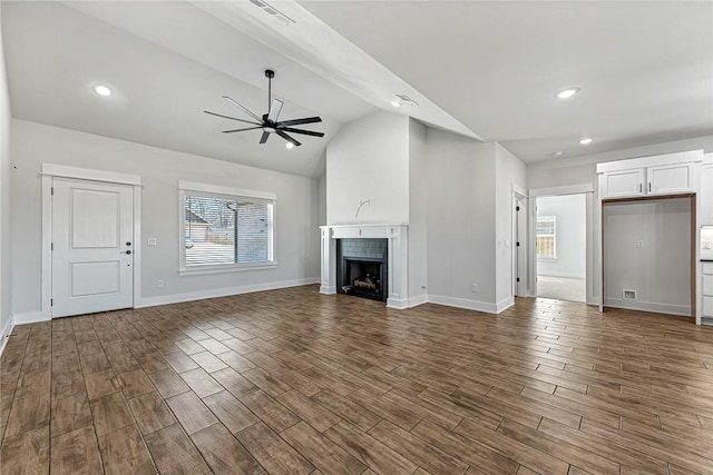 unfurnished living room featuring dark wood-type flooring, a fireplace, visible vents, and a healthy amount of sunlight