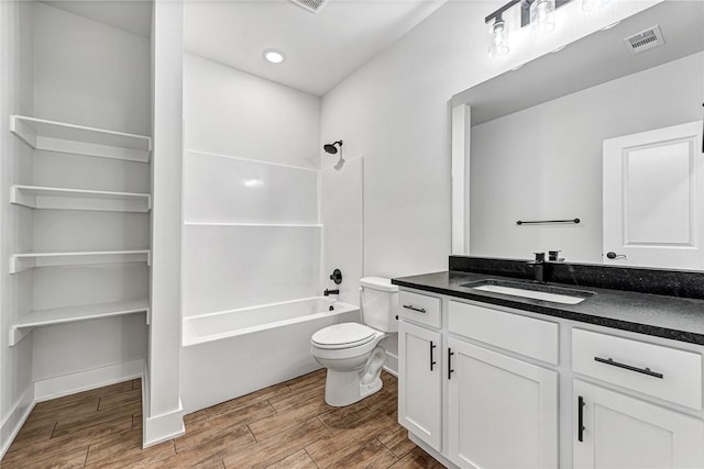 bathroom featuring toilet, vanity, visible vents, shower / washtub combination, and wood tiled floor