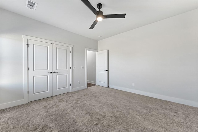 unfurnished bedroom featuring carpet, a closet, visible vents, ceiling fan, and baseboards