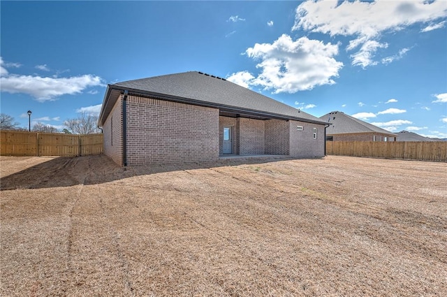 back of house with fence and brick siding