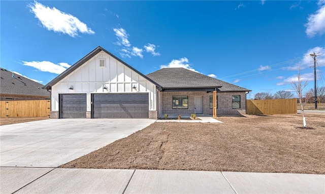 modern inspired farmhouse featuring brick siding, an attached garage, driveway, and fence