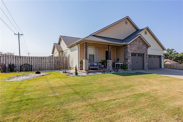 view of front of house featuring a front lawn, covered porch, and a garage