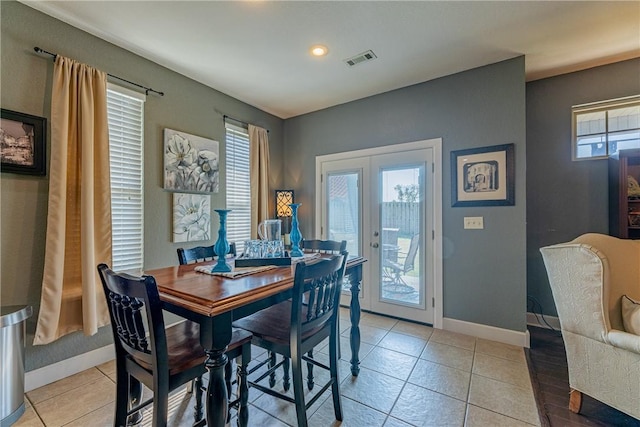 tiled dining room featuring french doors