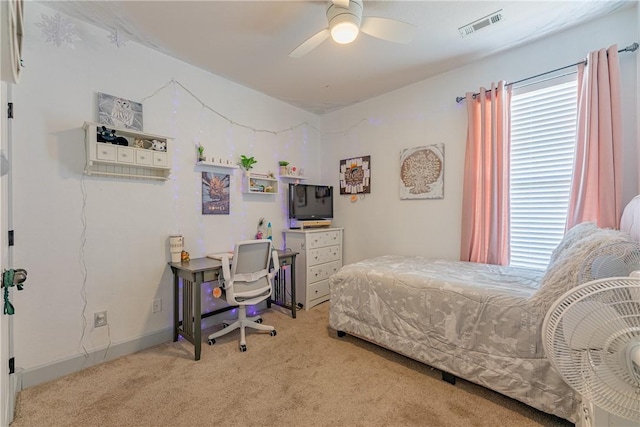 bedroom featuring ceiling fan, multiple windows, and carpet flooring