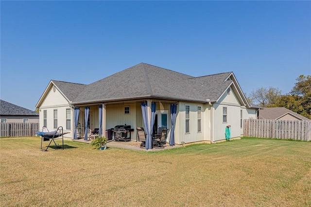 rear view of property featuring a patio area and a yard