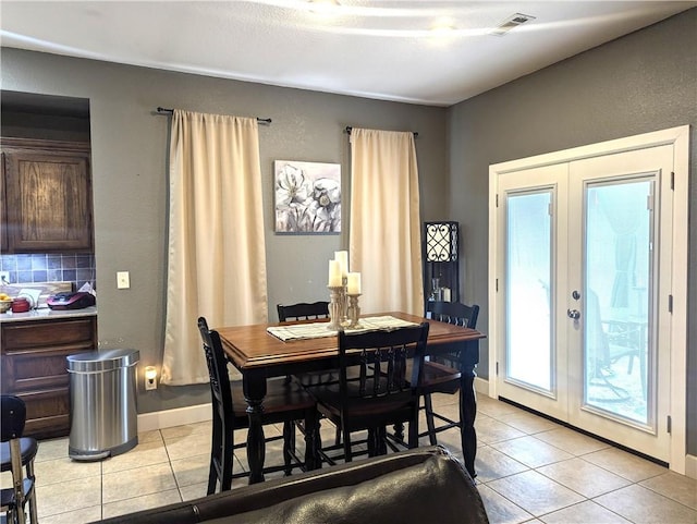 dining area featuring light tile patterned floors and french doors