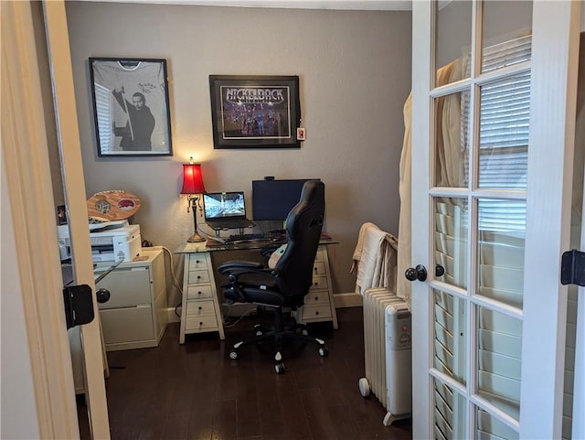 home office with dark hardwood / wood-style flooring and radiator heating unit