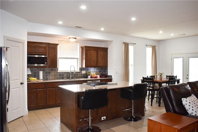 2111 Hunter Dr, Pea Ridge, AR 72751 - kitchen featuring light tile patterned floors, decorative backsplash, a sink, appliances with stainless steel finishes, and a center island