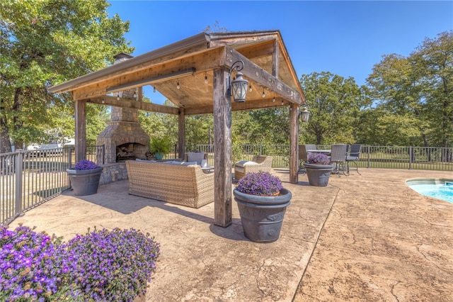 view of patio with a gazebo and an outdoor living space with a fireplace